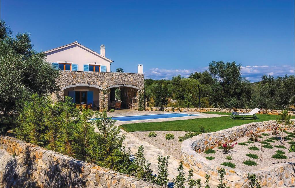 Villa con piscina y pared de piedra. en Nice Home In Zgaljici With Outdoor Swimming Pool, en Skrbčići