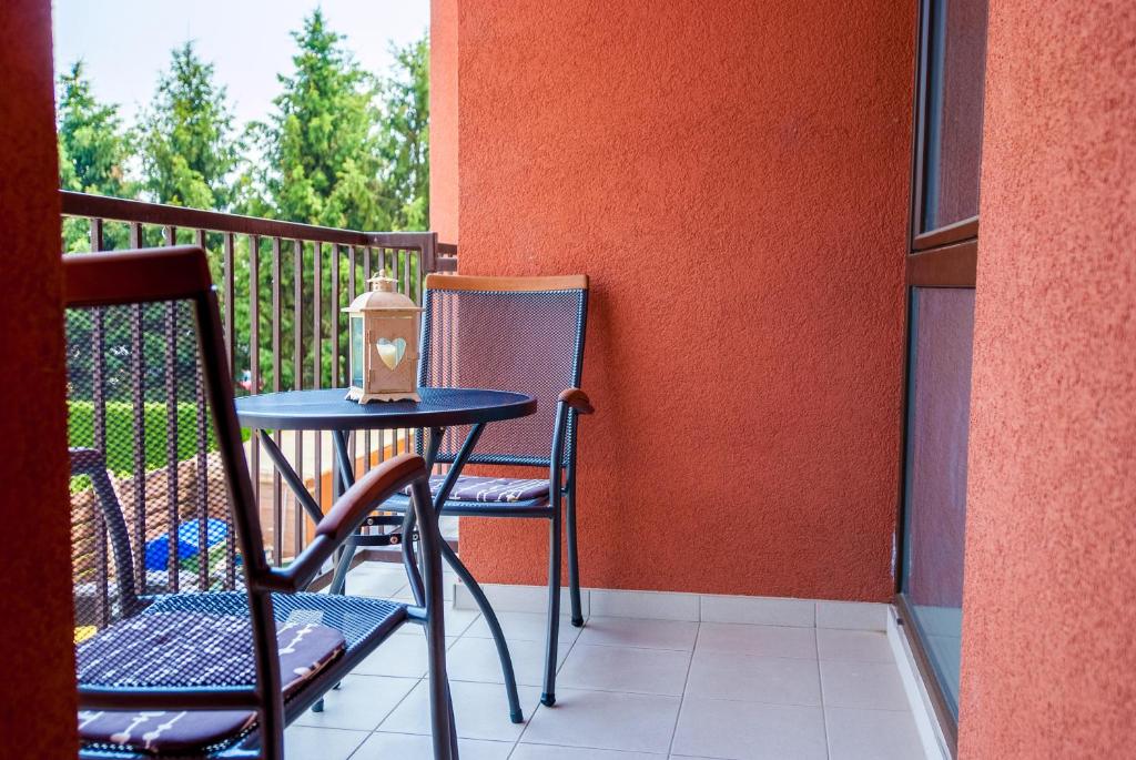 een kleine tafel en 2 stoelen op een balkon bij Apartments and Studios Perunika in Moravske-Toplice