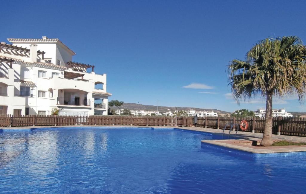 einem Pool vor einem Gebäude mit einer Palme in der Unterkunft 2 Bedroom Beautiful Apartment In Sucina in Sucina