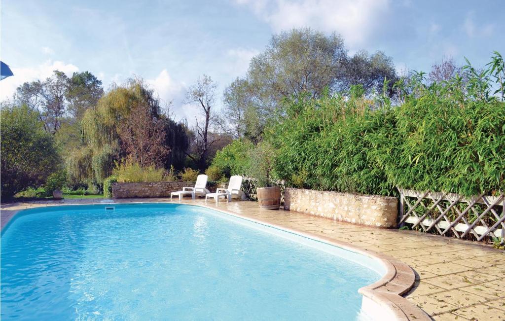 a swimming pool with two lawn chairs next to it at 2 Bedroom Cozy Home In Monestier in Monestier