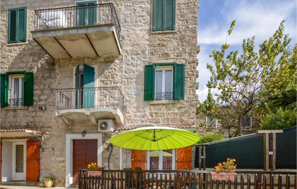 un parapluie jaune devant un bâtiment dans l'établissement Nice Apartment In Zonza With Kitchenette, à Zonza