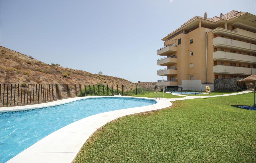 una piscina frente a un edificio en Amazing Apartment In Fuengirola-carvajal With 2 Bedrooms, Wifi And Outdoor Swimming Pool, en Santa Fe de los Boliches