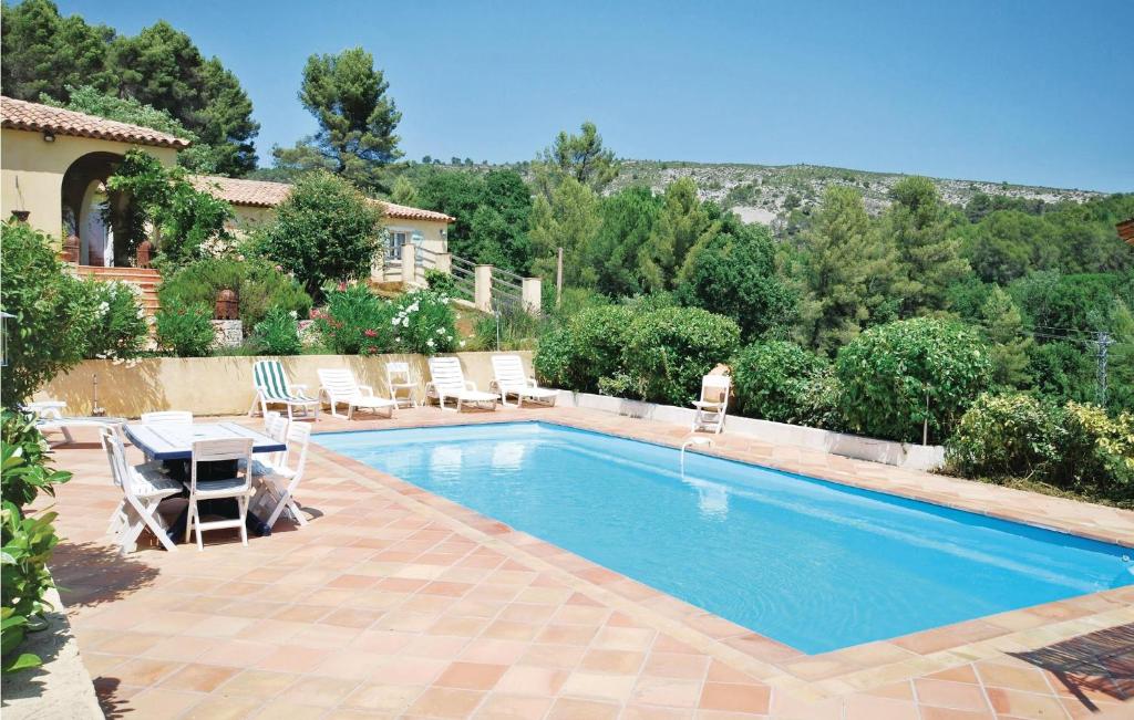 サレルヌにあるBeautiful Home In Salernes With 5 Bedrooms, Wifi And Outdoor Swimming Poolの椅子と家のある庭のスイミングプール