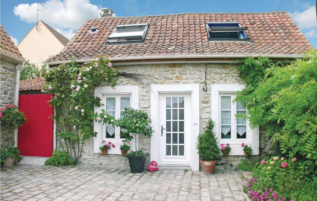 a stone house with a red door and flowers at Cozy Home In Ambleteuse With Wifi in Ambleteuse