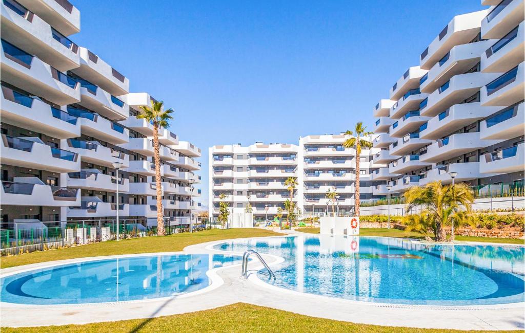 une piscine devant un grand immeuble d'appartements dans l'établissement Cozy Apartment In Los Arenales Del Sol, à Arenales del Sol
