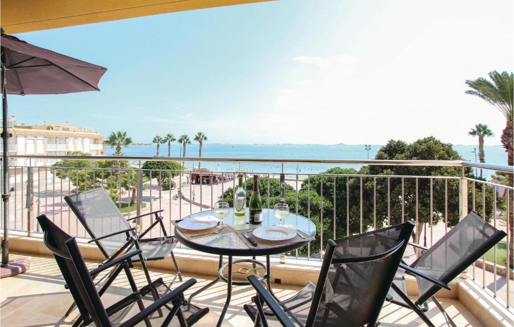 einen Balkon mit einem Tisch, Stühlen und Meerblick in der Unterkunft 3 Bedroom Beautiful Apartment In Los Alczares in Los Alcázares