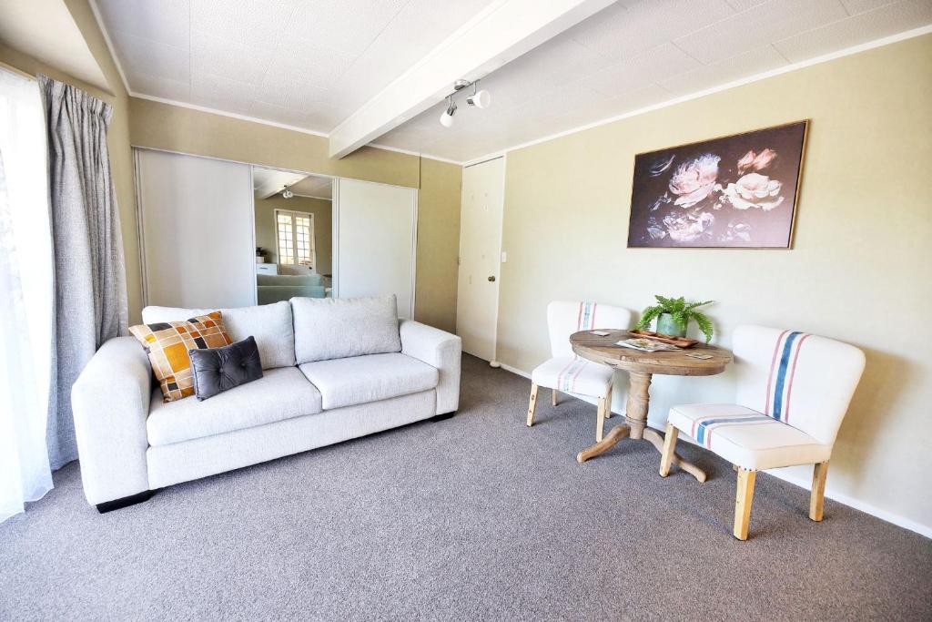 a living room with a couch and a table at Spa pool Treat in Taupo