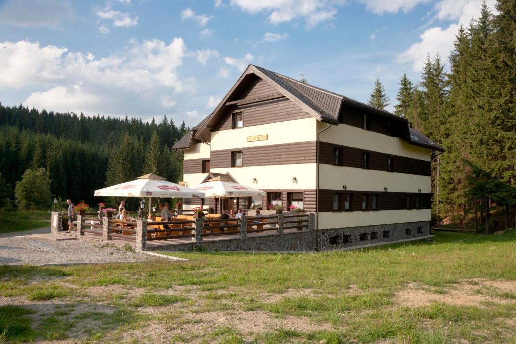 a large building with people standing outside of it at Penzión Kohútik in Oravská Lesná