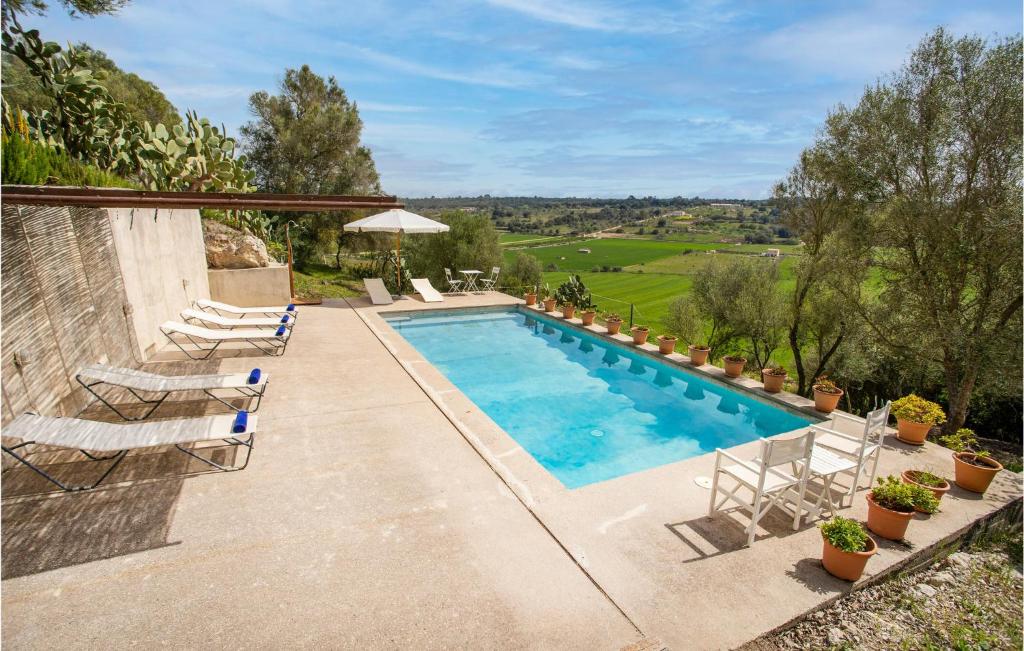 uma piscina com cadeiras e vista para o campo em Cozy Home In Ariany With Outdoor Swimming Pool em Ariany