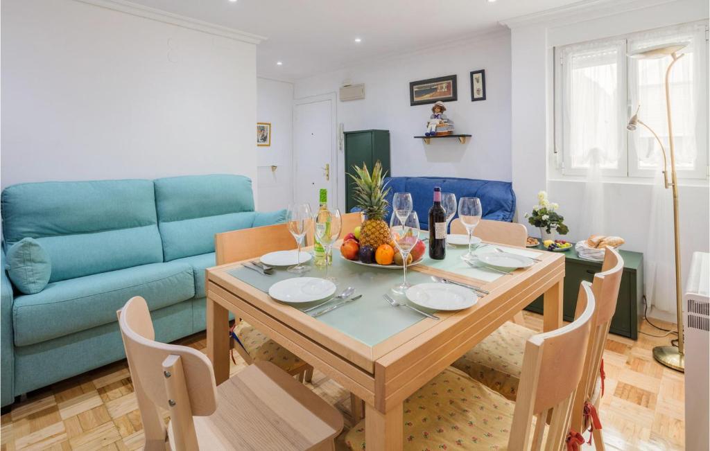 奧維多的住宿－Cozy Apartment In Oviedo With Kitchenette，一间带桌子和蓝色沙发的用餐室