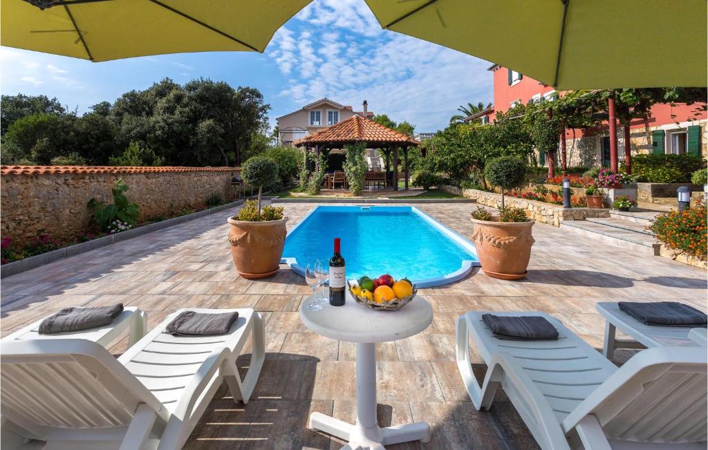 a patio with a table and chairs and a pool at Nice Home In Ugljan With Wifi in Ugljan