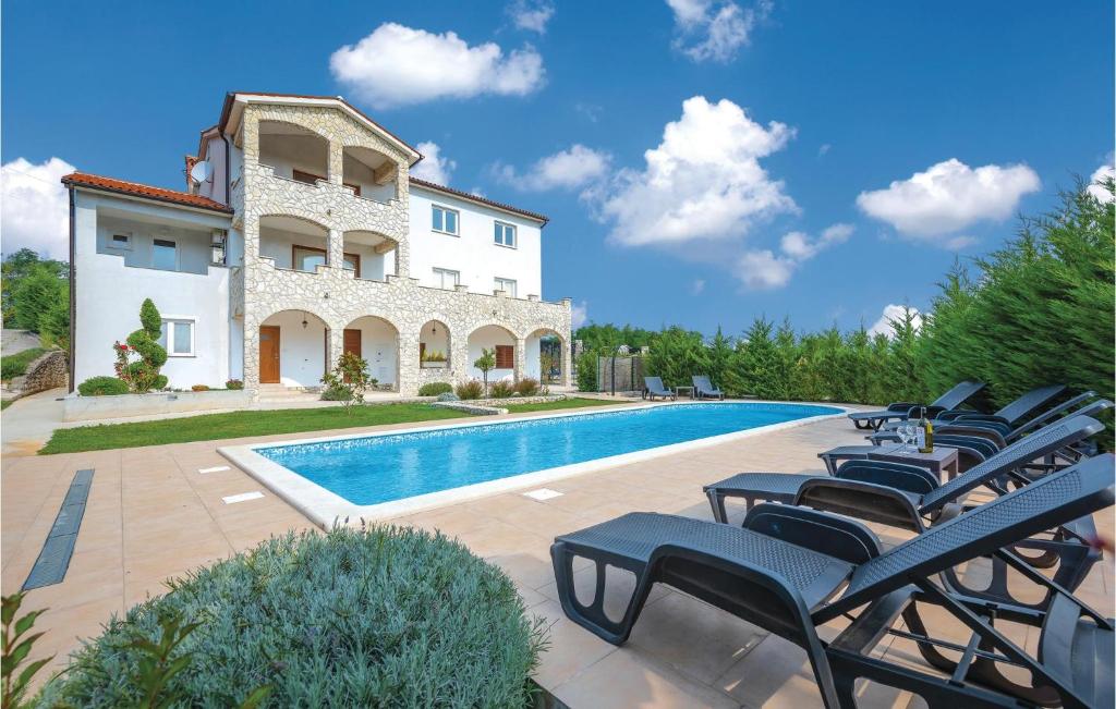 a villa with a swimming pool and lounge chairs at Gorgeous Home In Labin-krsan With Wifi in Kršan