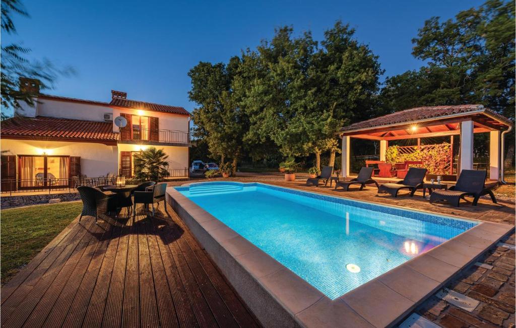 podwórko z basenem i domem w obiekcie Beautiful Home In Kapelica With 4 Bedrooms, Wifi And Outdoor Swimming Pool w mieście Raša