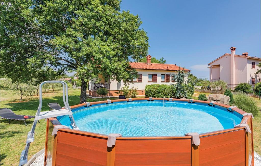 een zwembad in een tuin met een huis bij Cozy Home In Labin With Kitchen in Labin