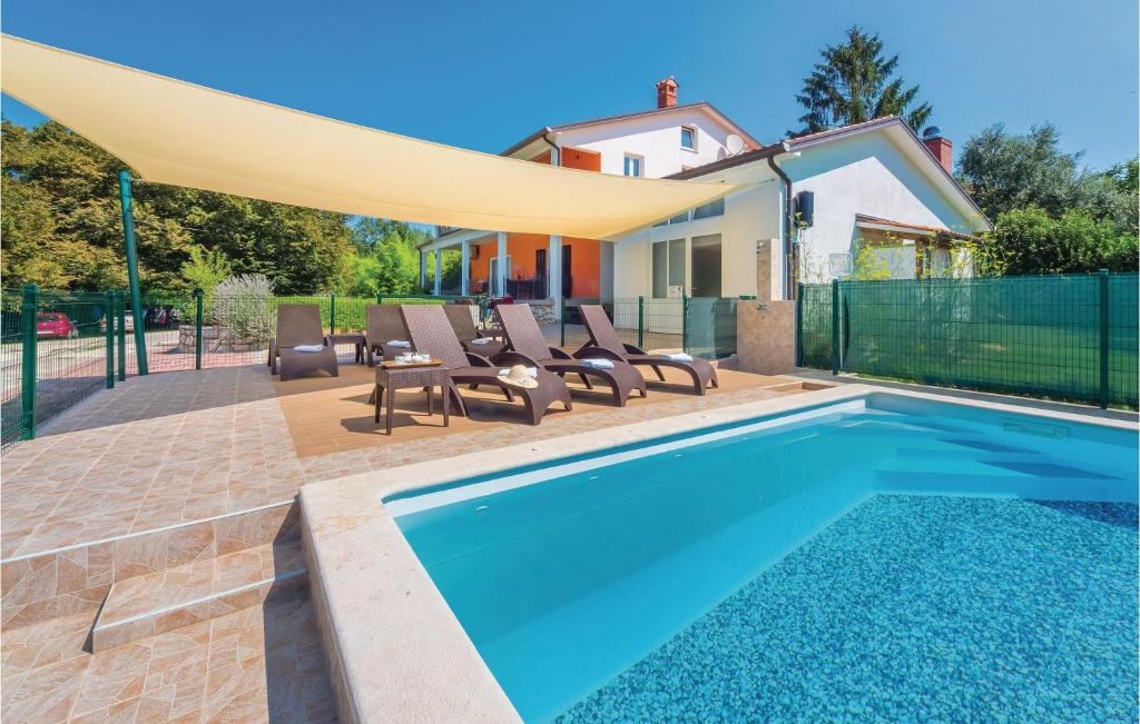 ein Pool mit Stühlen und ein großer Regenschirm darüber in der Unterkunft Amazing Home In Nedescina With 6 Bedrooms, Wifi And Outdoor Swimming Pool in Santalezi