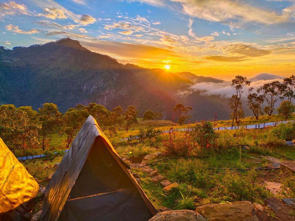 a tent in a field with the sunset in the background at Eco Lodge Haputale-Camping Sri lanka in Haputale