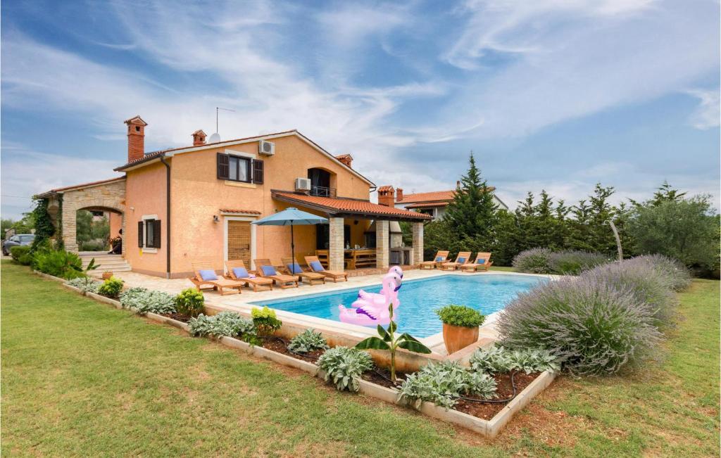 une maison avec une piscine dans la cour dans l'établissement Stunning Home In Pula With Outdoor Swimming Pool, à Muntić