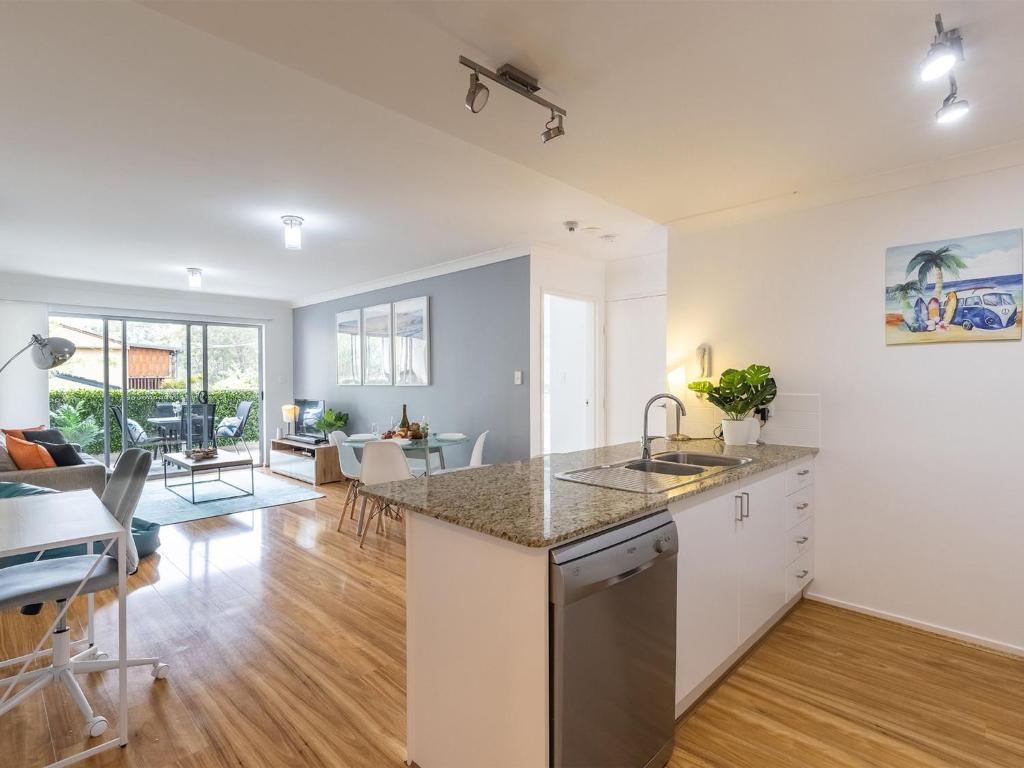 an open kitchen and living room with a dining room at Mikalex 10 2 Shoal Bay Road Nelson Bay in Nelson Bay