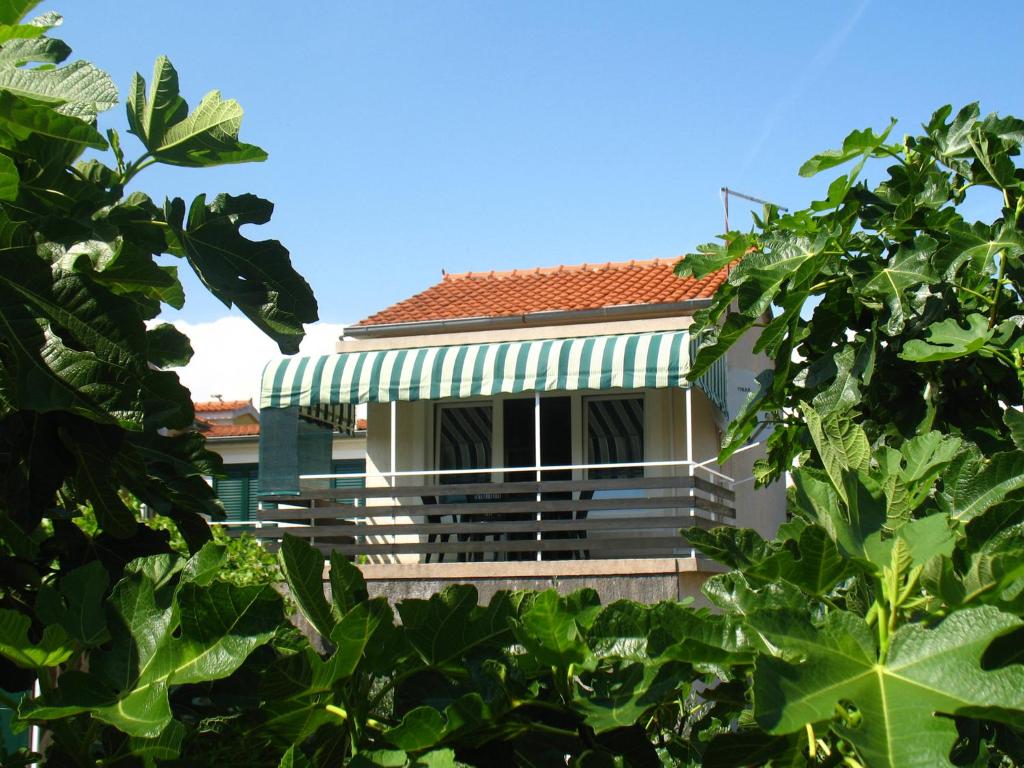 a building with a green awning and trees at Apartment M in Vodice