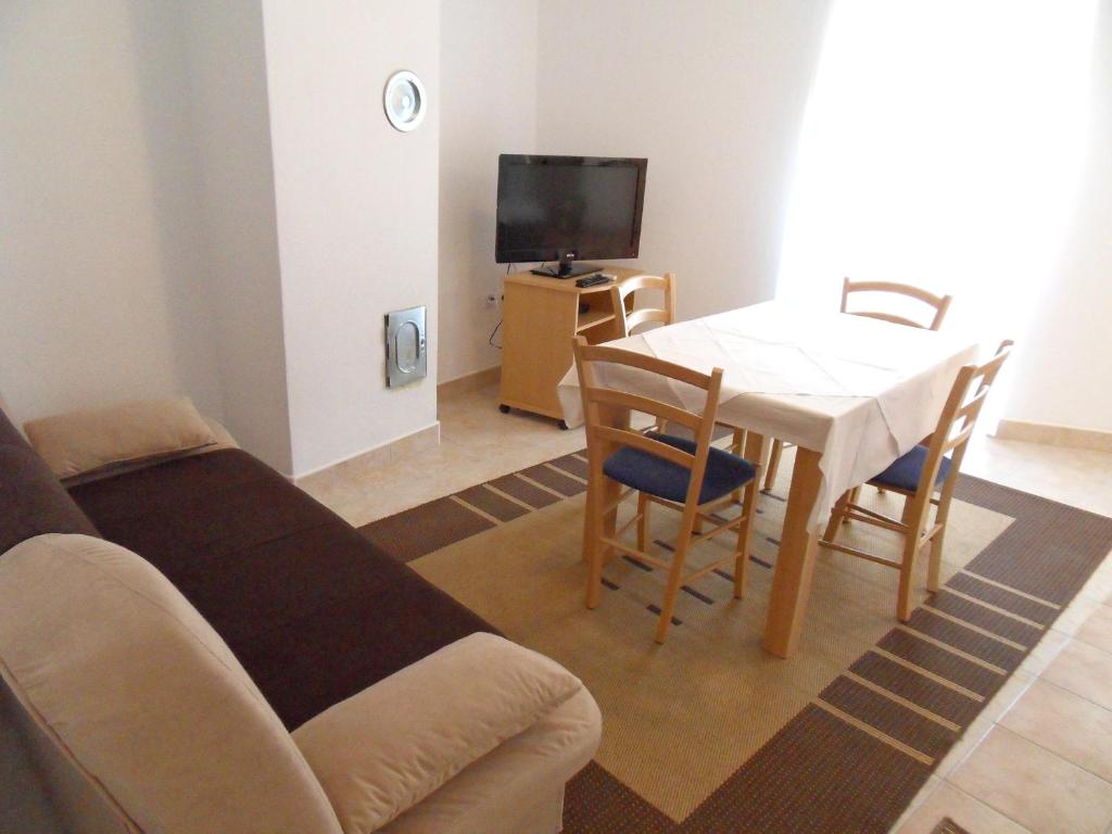 a living room with a table and a couch at Apartments Petricevic 2 in Selce