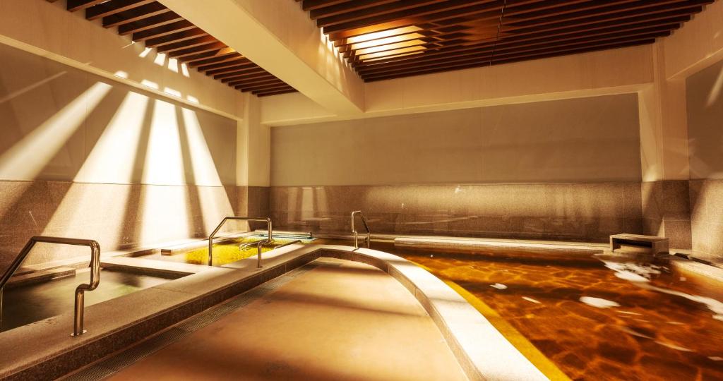 那覇市にあるＨＯＴＥＬ　ＳＡＮＳＵＩ　ＮＡＨＡ　琉球温泉　波之上の湯のバスルーム(バスタブ、シンク付)