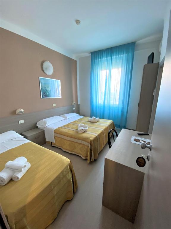 pokój hotelowy z dwoma łóżkami i oknem w obiekcie Hotel New Primula w Rimini