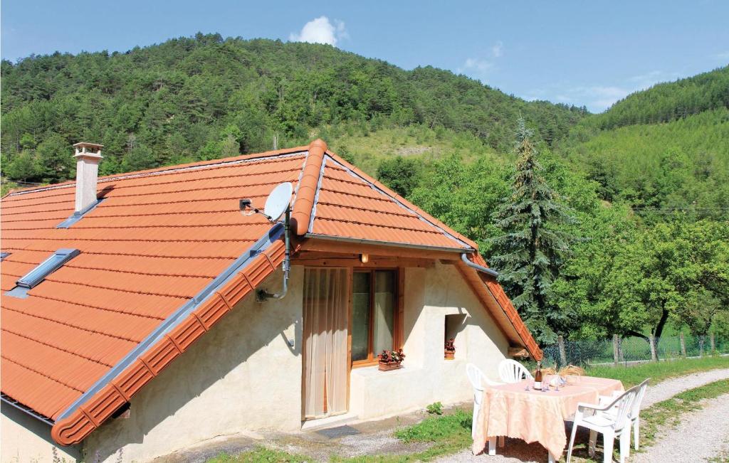 una casa con mesa, sillas y techo en Gte Du Jocou, en Glandage