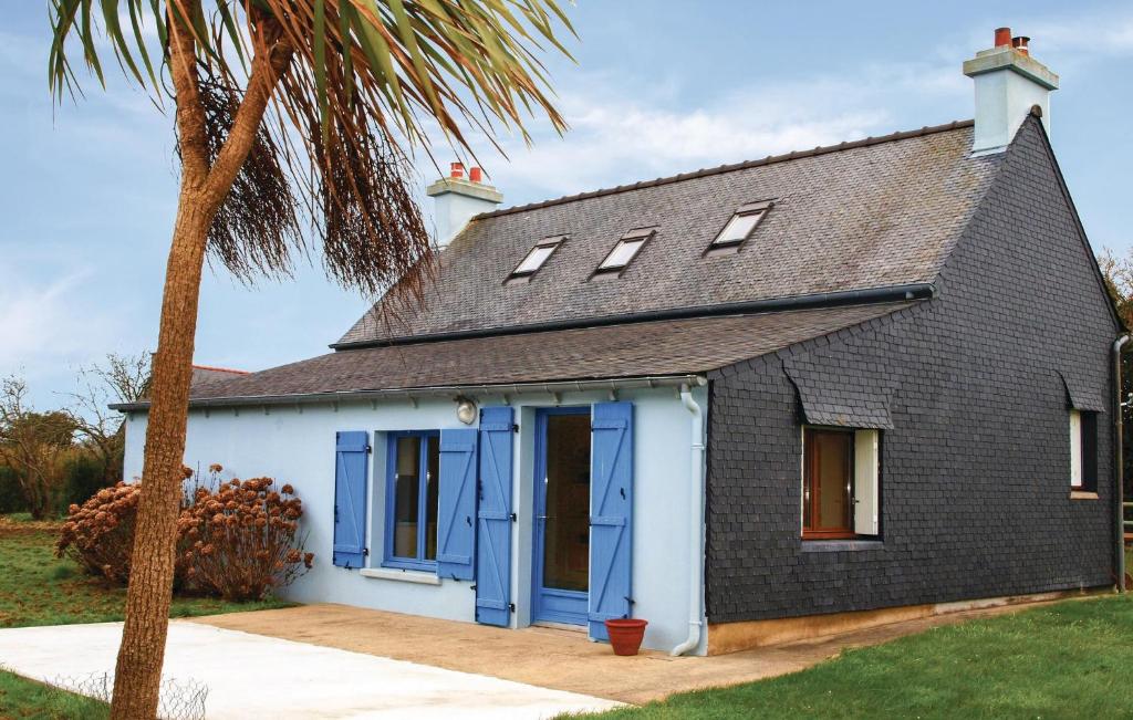 a black and white house with blue doors and a palm tree at Stunning Home In Kerbors With 3 Bedrooms in Kerbors