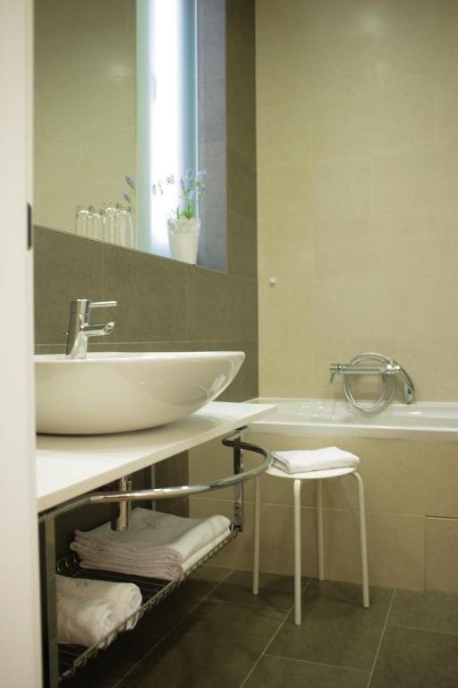 a bathroom with a white sink and a tub at Guest House Villa Dagmar in Crikvenica
