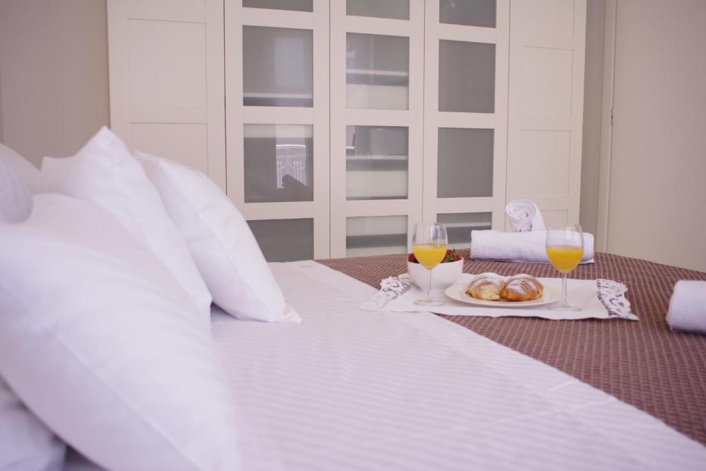 a bed with a plate of food and two glasses of orange juice at Guest House Villa Dagmar in Crikvenica