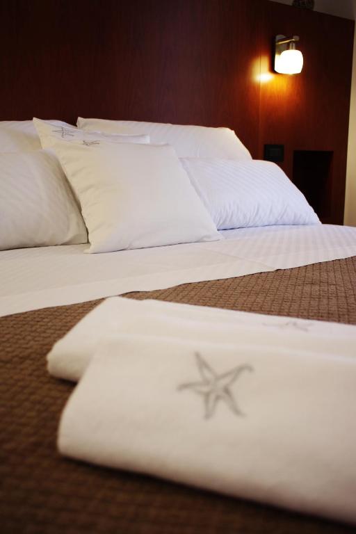 two beds with white sheets and a starfish on them at Guest House Villa Dagmar in Crikvenica