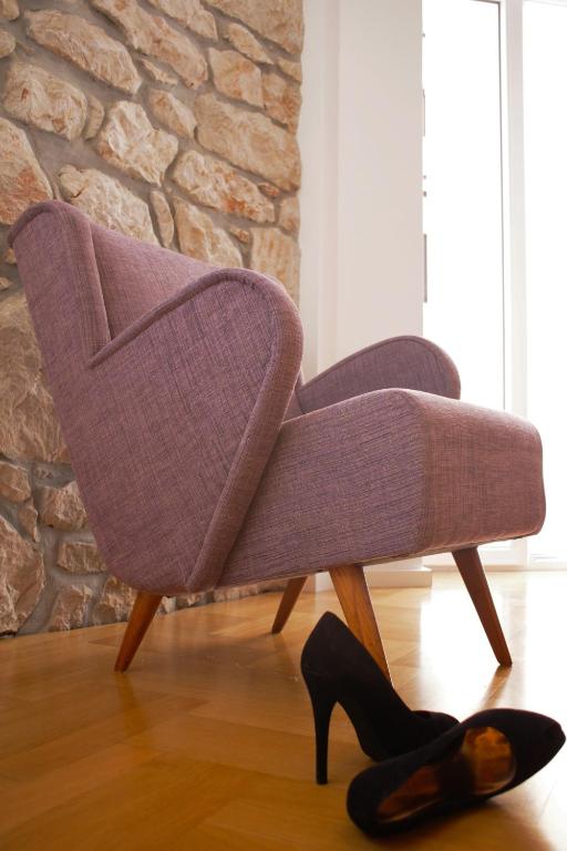 a purple chair with a pair of shoes on the floor at Guest House Villa Dagmar in Crikvenica