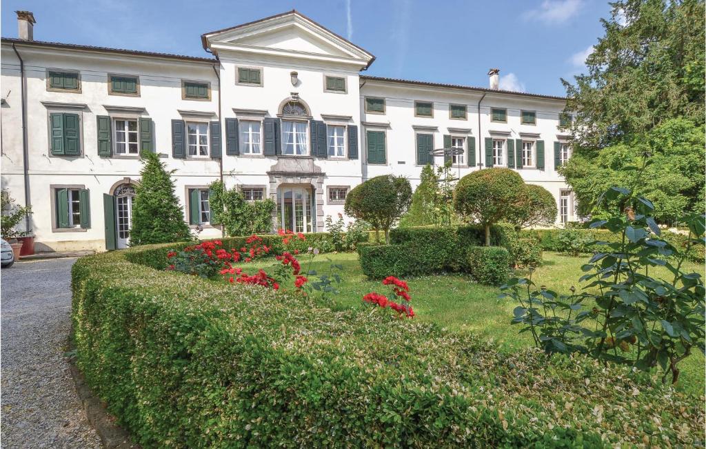 Un gran edificio blanco con un jardín delante. en Casa Orange, en Tissano