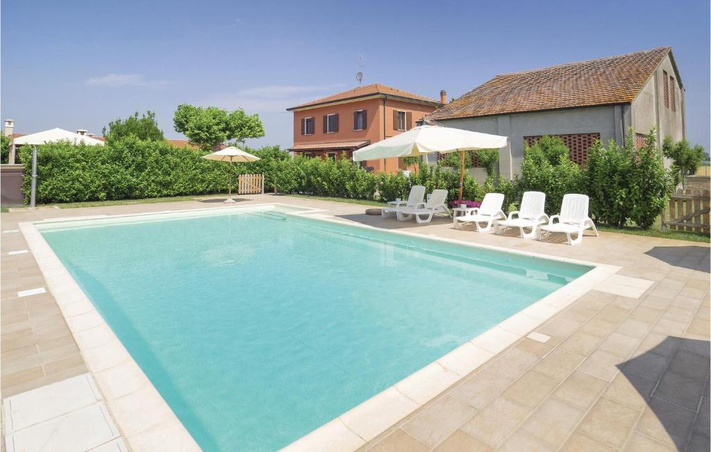 a swimming pool with chairs and a house at Casale Delle Rose in Lendinara
