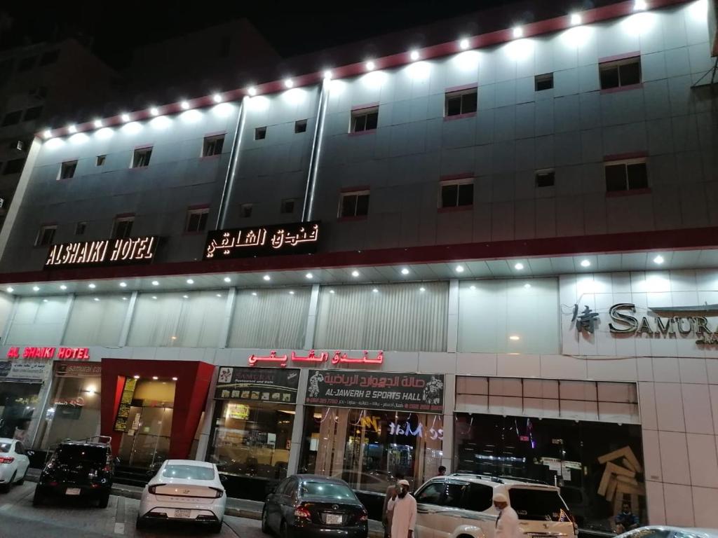a building with cars parked in front of it at Al Shaiki Hotel in Al Jubail