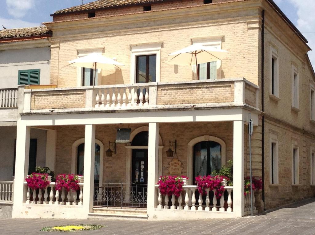 ein Gebäude mit einem Balkon mit Blumen und Sonnenschirmen in der Unterkunft Relais Borgo sul Mare Ospitalità diffusa in Silvi Paese