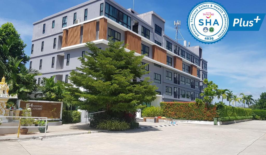 a large white building with a tree in front of it at S4 Nai Yang Beach - SHA EXTRA PLUS in Nai Yang Beach