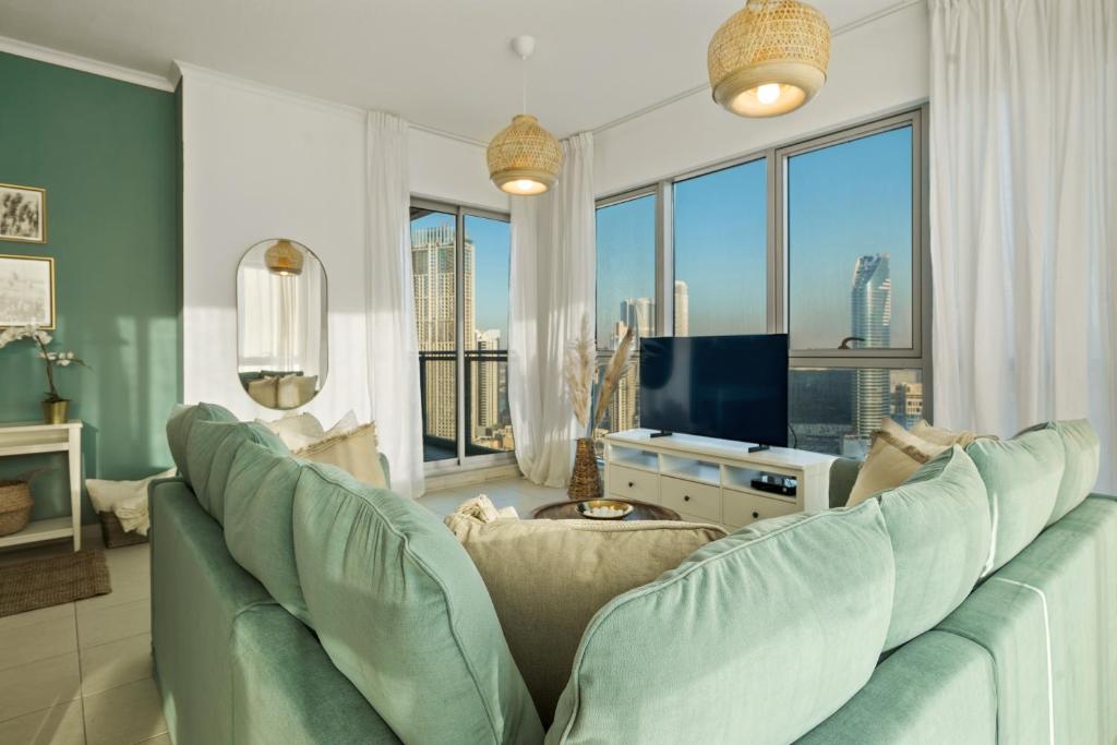 uma sala de estar com um sofá e uma televisão em Chic and Zen Apartment, Near Burj Khalifa Tower em Dubai