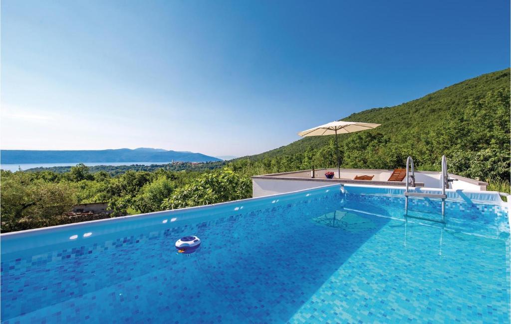 a swimming pool with a mountain in the background at 2 Bedroom Gorgeous Home In Moscenicka Draga in Martina