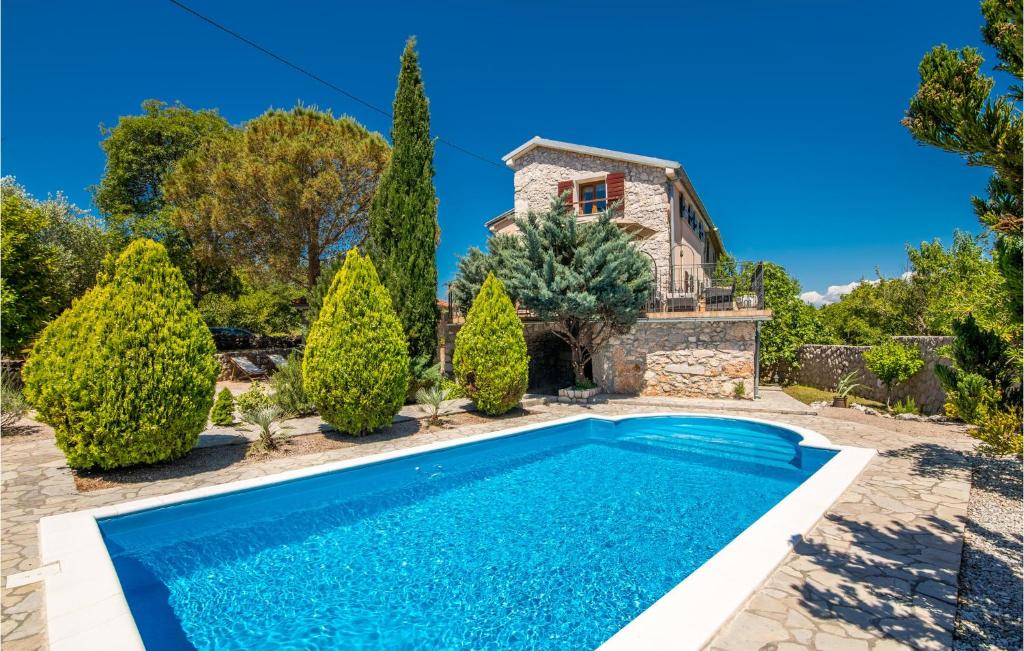 a pool in front of a house with trees at 2 Bedroom Pet Friendly Home In Gostinjac in Gostinjac