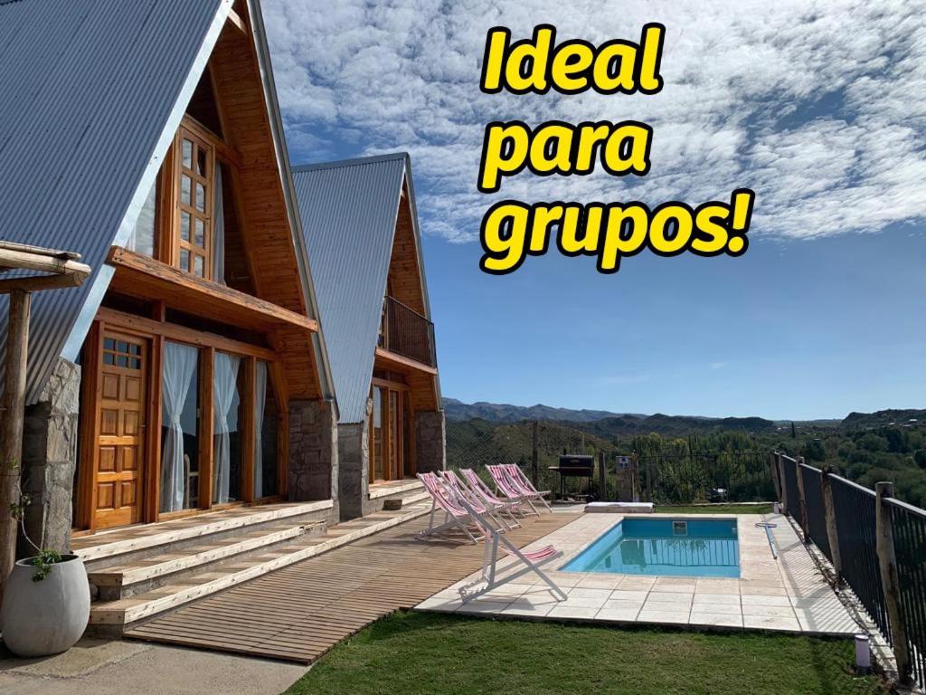 een huis met een zwembad en een bord met ideale gyroscopen bij Cabañas El Mirador in El Volcán
