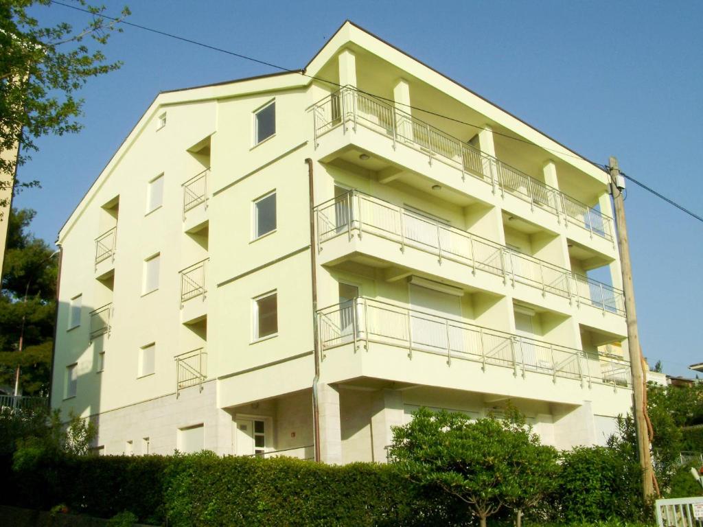 Apartments Petricevic في سيلتسي: مبنى ابيض فيه بلكونات جنبه