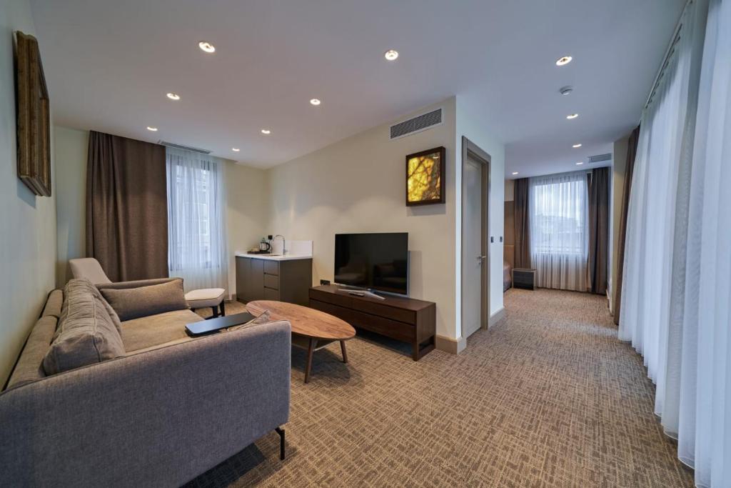 a living room with a couch and a television at Selini Hotel İstanbul Airport in Istanbul