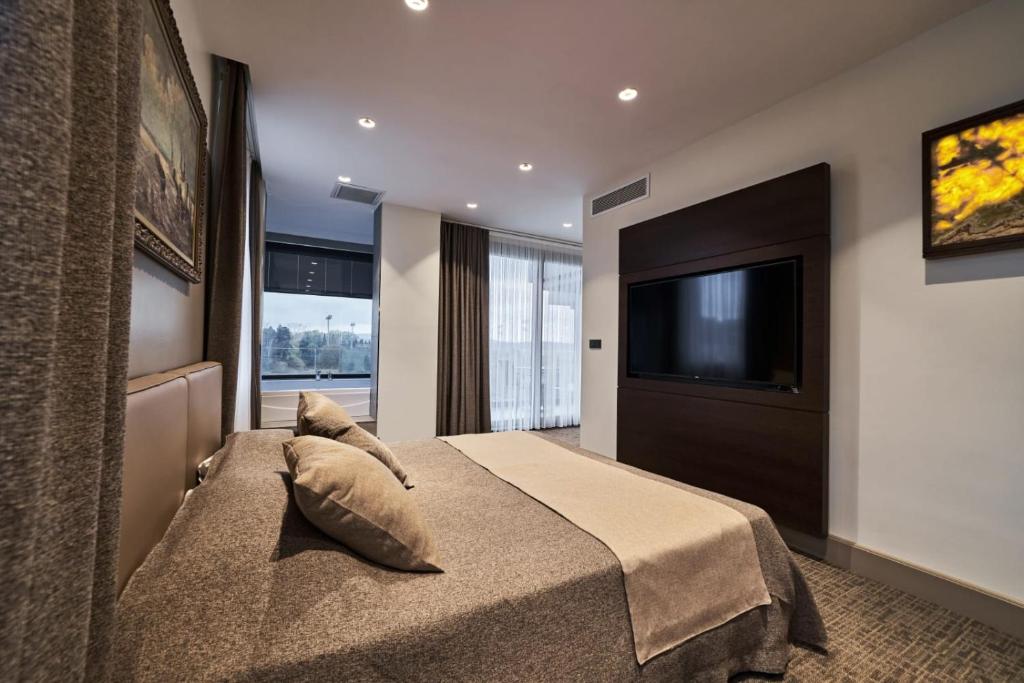 a bedroom with a bed and a flat screen tv at Selini Hotel İstanbul Airport in Istanbul