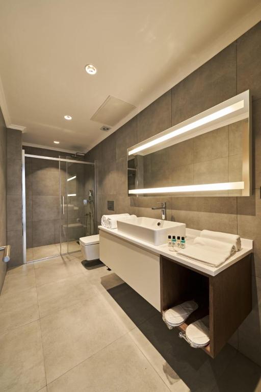 a bathroom with a sink and a tub and a toilet at Selini Hotel İstanbul Airport in Istanbul