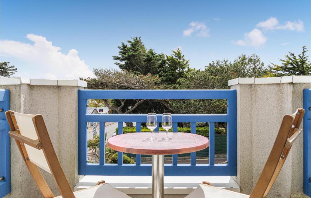 une table avec deux verres à vin sur un balcon dans l'établissement Amazing Apartment In Hauteville-Sur-Mer, à Hauteville-sur-Mer
