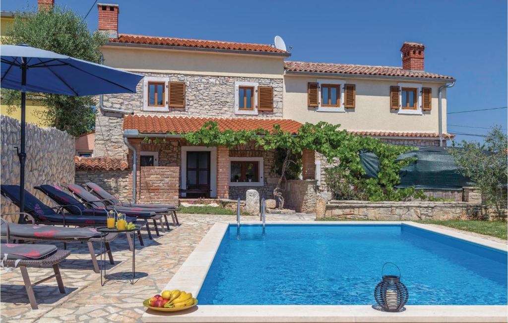 a villa with a swimming pool in front of a house at Beautiful Home In Liznjan With Ethernet Internet in Ližnjan