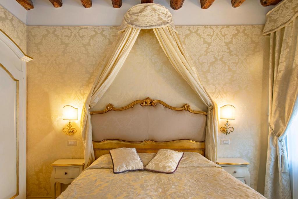 a bedroom with a canopy bed with two pillows on it at B&B Patatina in Venice