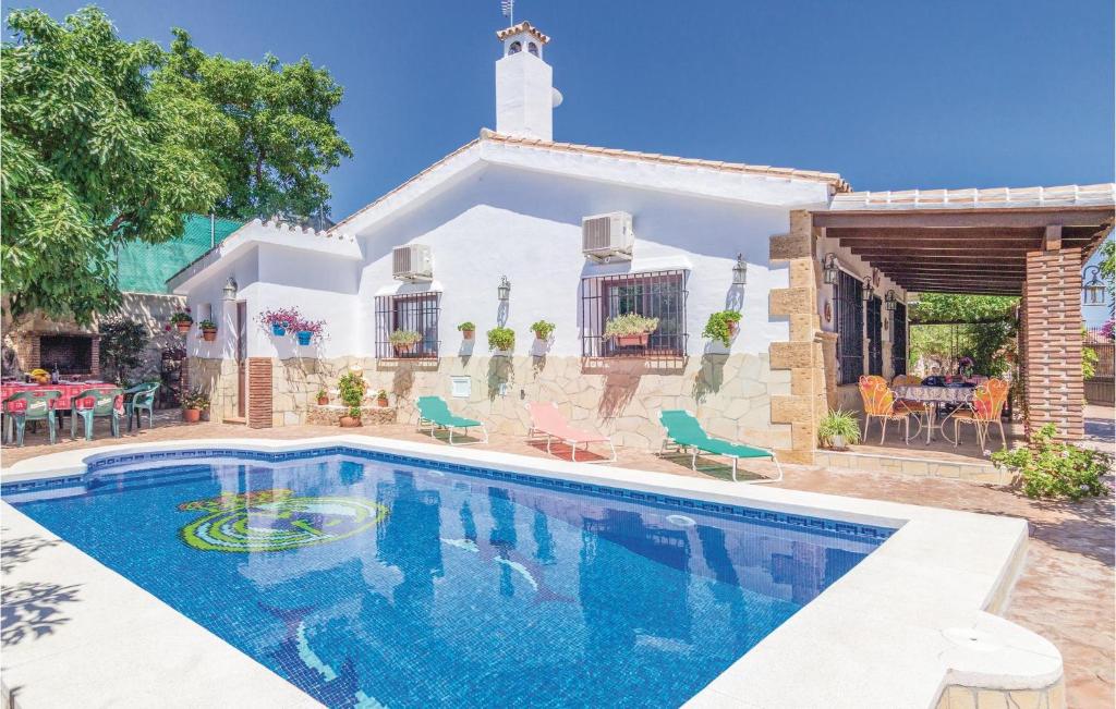 a villa with a swimming pool in front of a house at Awesome Home In Mijas With House A Mountain View in Mijas