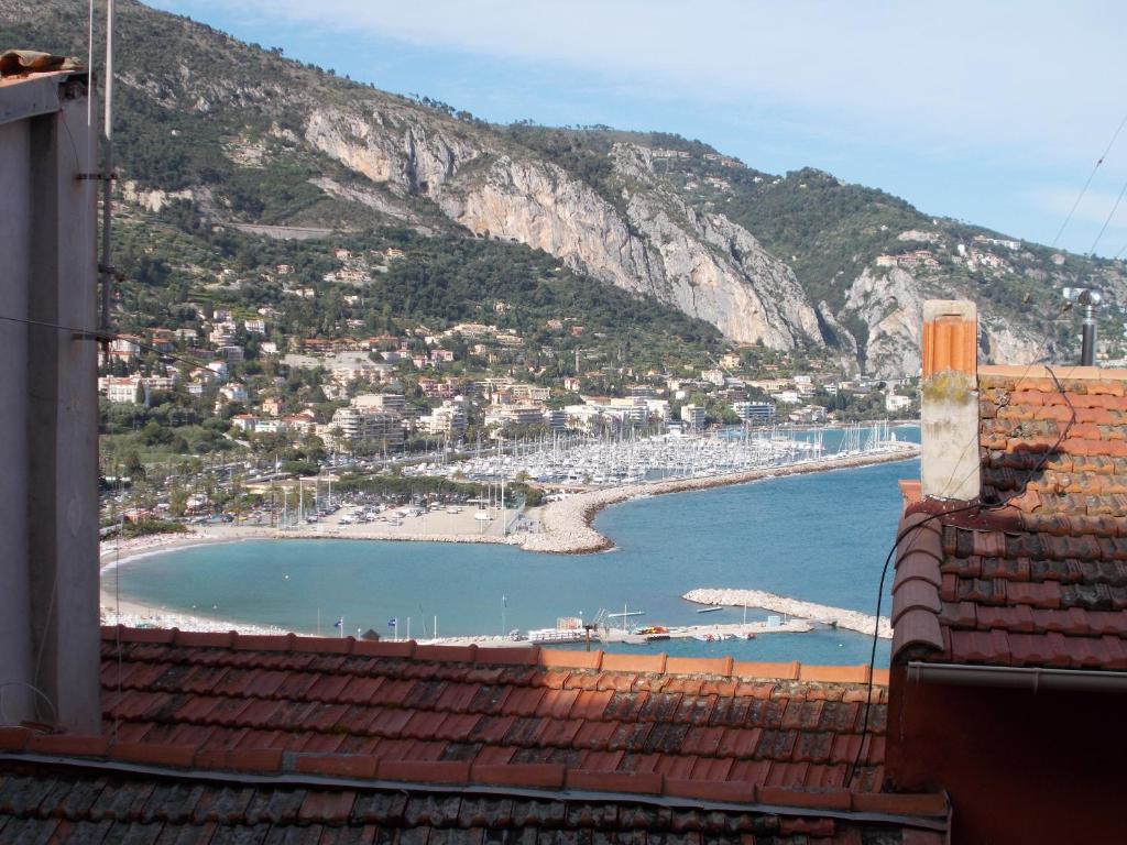 une vue sur une plage et l'océan depuis un immeuble dans l'établissement Le Campanin, à Menton